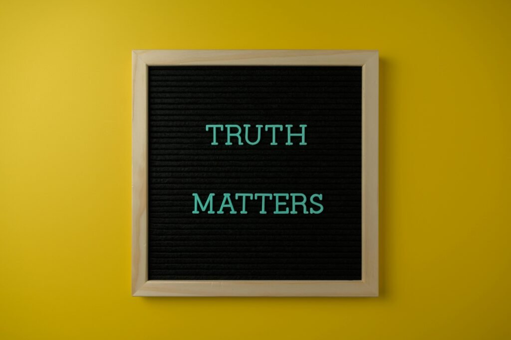 Close-up of black letter board with 'Truth Matters' message on yellow background.